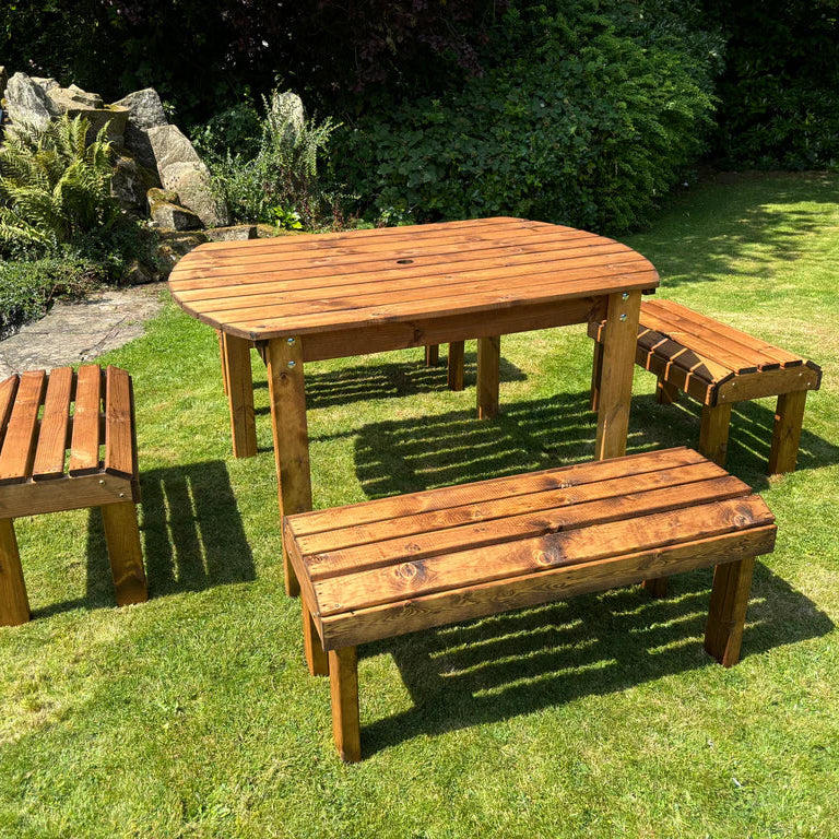 KNIGHTS SIX SEATER RECTANGULAR TABLE SET - side view of table on lawn. pond, stones, ferns, bushes. 