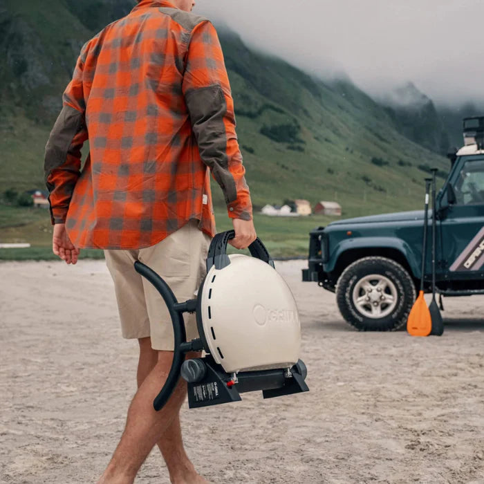 A cream coloured O-Grill 500 being carried along a beach