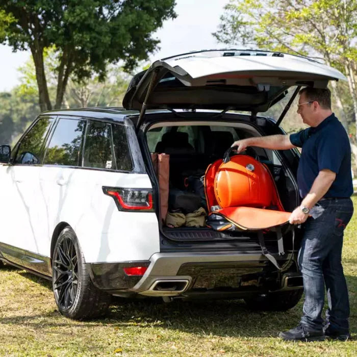 The O-Grill 500 in orange being backed into a car boot