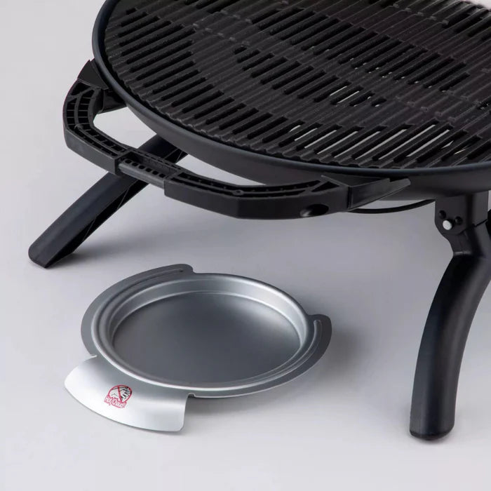 A drip tray for the black o-grill 600 on a grey table