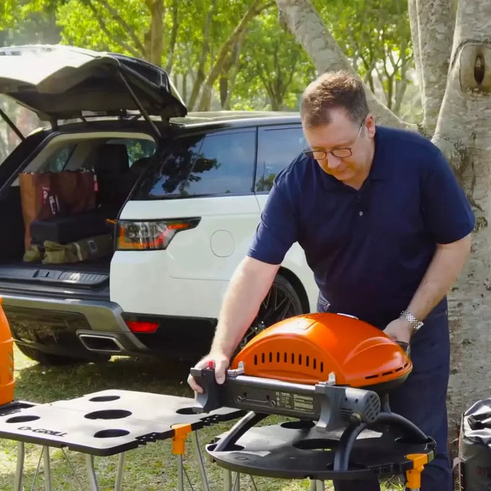 An orange o-grill 600 being prepared for cooking