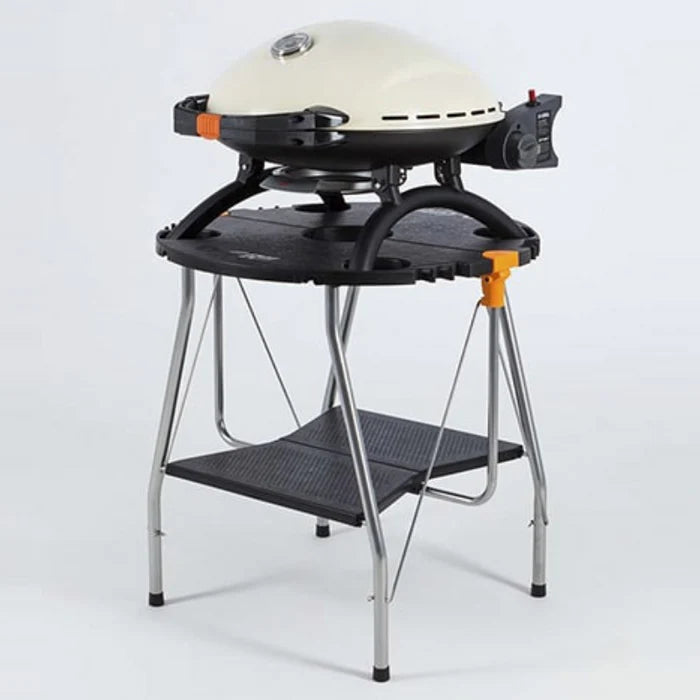 A cream o-grill 600 standing on a fold out table