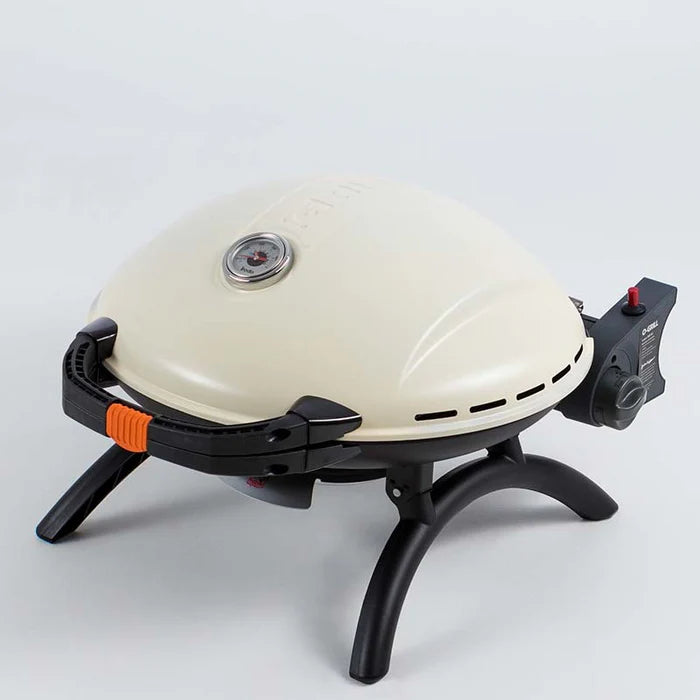 A closeup of the cream O-Grill 900 standing on its folding legs